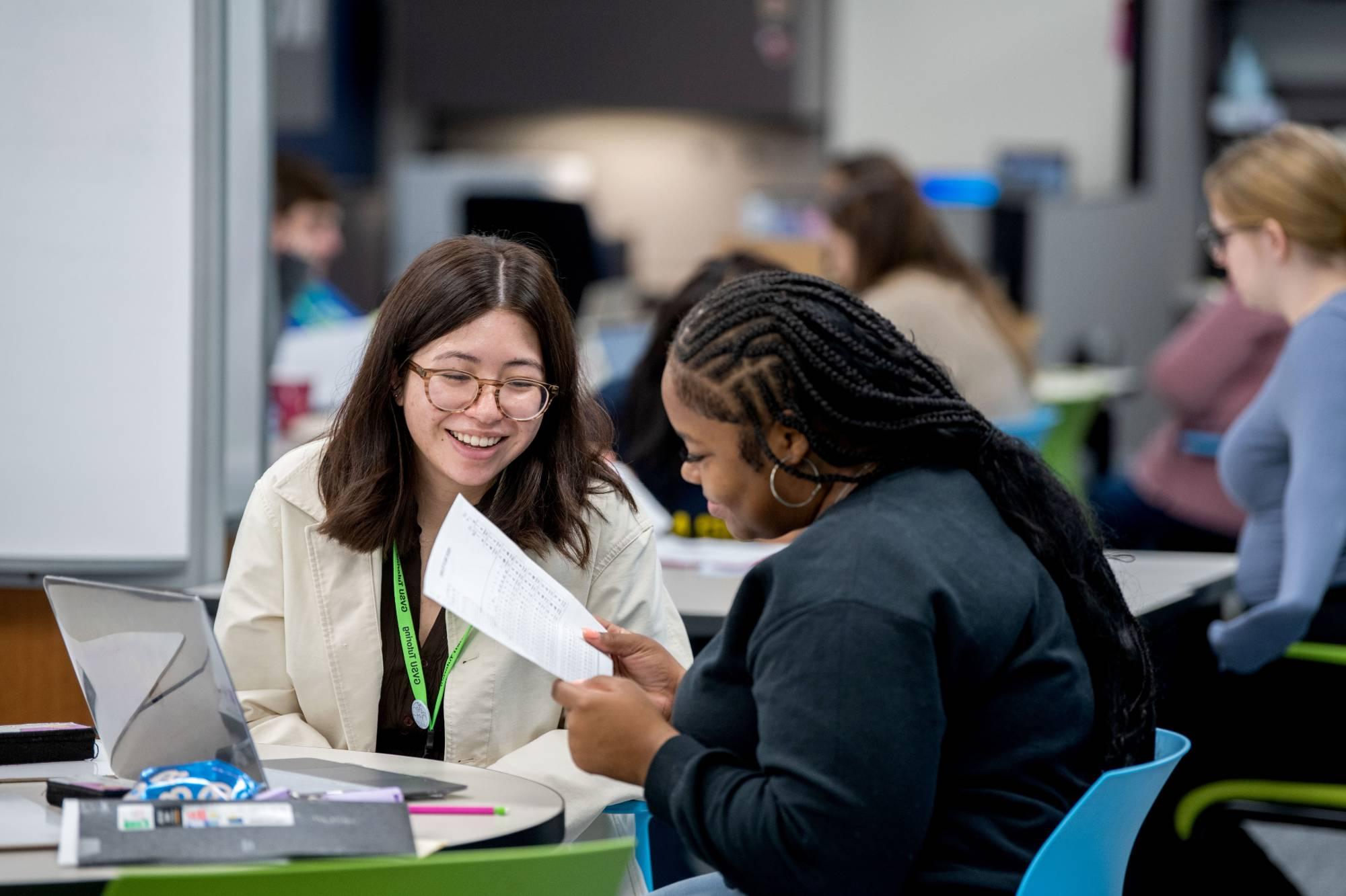 Students smiling at a study table in the tutoring center